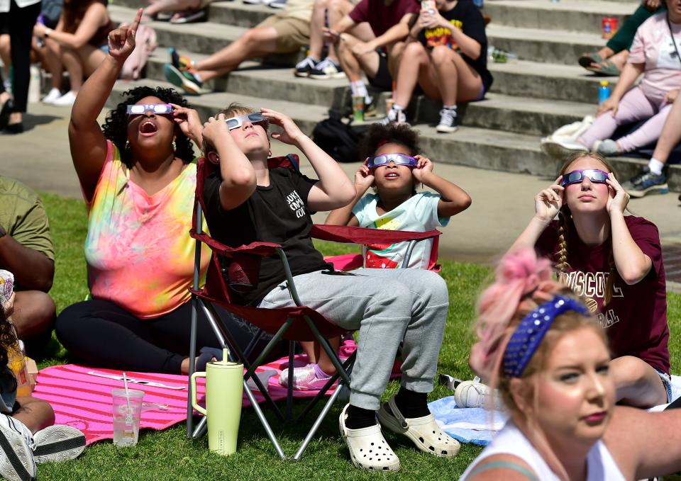 Spectators excitedly watch as the partial solar eclipse reaches its peak coverage at the viewing event at Monday's University of North Florida in Jacksonville.