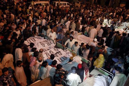 Pakistani relatives gather beside the covered bodies of victims who were killed in suicide bomb attack in Wagah border near Lahore November 2, 2014. REUTERS/Mohsin Raza