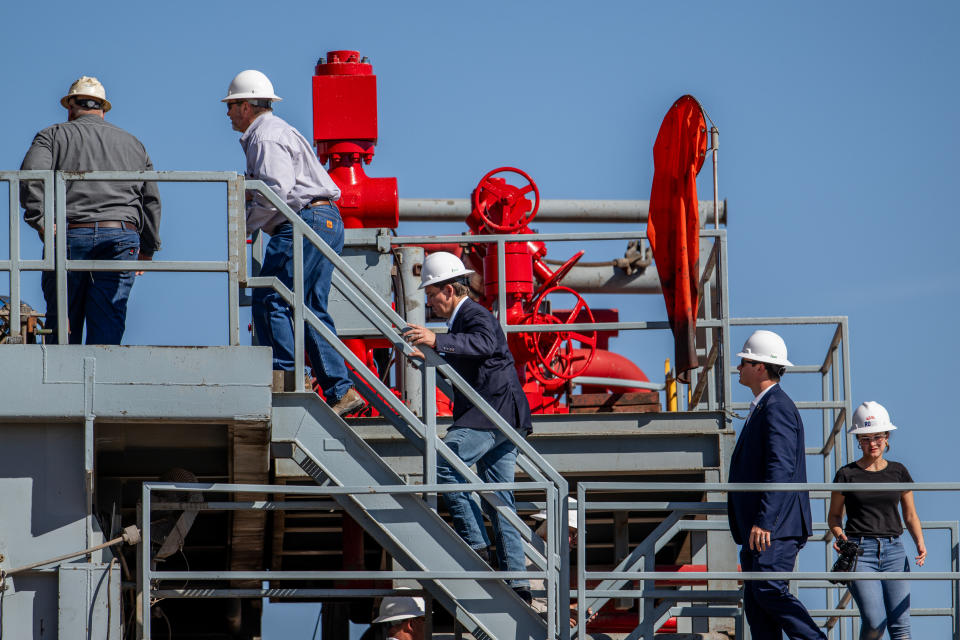 Florida Governor Ron DeSantis, wearing a hard hat, tours an oil rig in Texas.