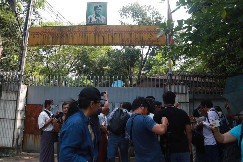 Journalists gather during an auction outside the residence of ousted leader Aung San Suu Kyi in Yangon (AP)