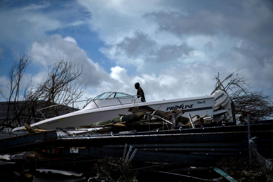 A soldier behind a boat sitting in the rubble of Hurricane Dorian in Abaco, Bahamas, Monday, Sept. 16, 2019. Dorian hit the northern Bahamas on Sept. 1, with sustained winds of 185 mph (295 kph), unleashing flooding that reached up to 25 feet (8 meters) in some areas. (AP Photo/Ramon Espinosa)