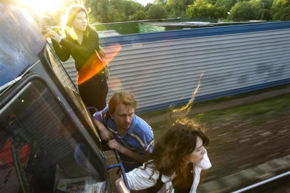 Political activists Yekaterina Samutsevich (L) Oleg Vorotnikov (C) and Natalia Sokol travel on the outside of a commuter train, refusing to buy tickets, outside of Moscow, June 2, 2008. Yekaterina Samutsevich later became a member of the Russian female punk group Pussy Riot.