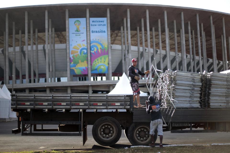 Men load metallic structures into a vehicle outside the Mane Garrincha National Stadium. (Ueslei Marcelino/Reuters)
