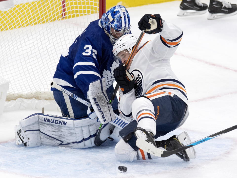 Edmonton Oilers right wing Josh Archibald (15) runs into Toronto Maple Leafs goaltender Jack Campbell (36) while chasing the puck during second-period NHL hockey game action in Toronto, Saturday, March 27, 2021. (Frank Gunn/The Canadian Press via AP)