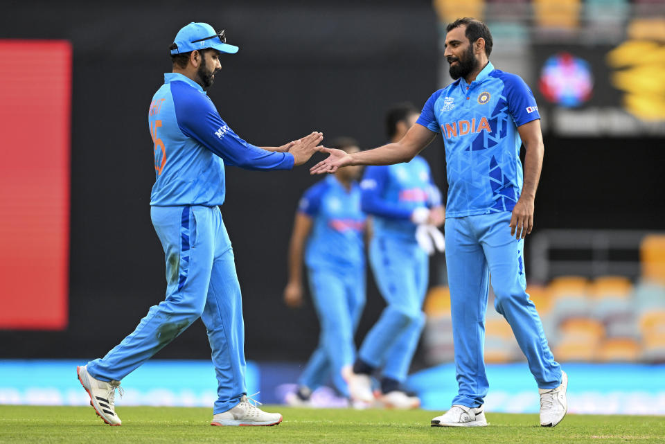 Indian captain Rohit Sharma, left, gestures to teammate Mohammed Shami following the ICC T20 World Cup warm-up cricket match between Australia and India at the Gabba in Brisbane, Australia, Monday, Oct. 17, 2022. (Dave Hunt/AAP Image via AP)