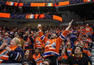 FILE - In this Oct. 2, 2019, file photo, Edmonton Oilers fans celebrate a goal against the Vancouver Canucks during the first period of an NHL hockey game in Edmonton, Alberta. Many NHL issues are similar to those facing North America’s other major professional leagues, such as when fans will be allowed to attend games. Others are more distinct to hockey, such as the effect the drop of the Canadian dollar will have on a league with seven of its 31 teams based north of the border. (Jason Franson/The Canadian Press via AP, File)