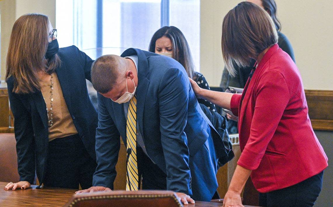 Eric DeValkenaere, center, is comforted by attorneys Dawn Parsons, left, and Molly Hastings. Jackson County Circuit Court Judge J. Dale Youngs announced on Tuesday, Nov. 9, 2021, that he found Eric DeValkenaere, a Kansas City police detective, guilty in the fatal December 2019 shooting of Cameron Lamb.