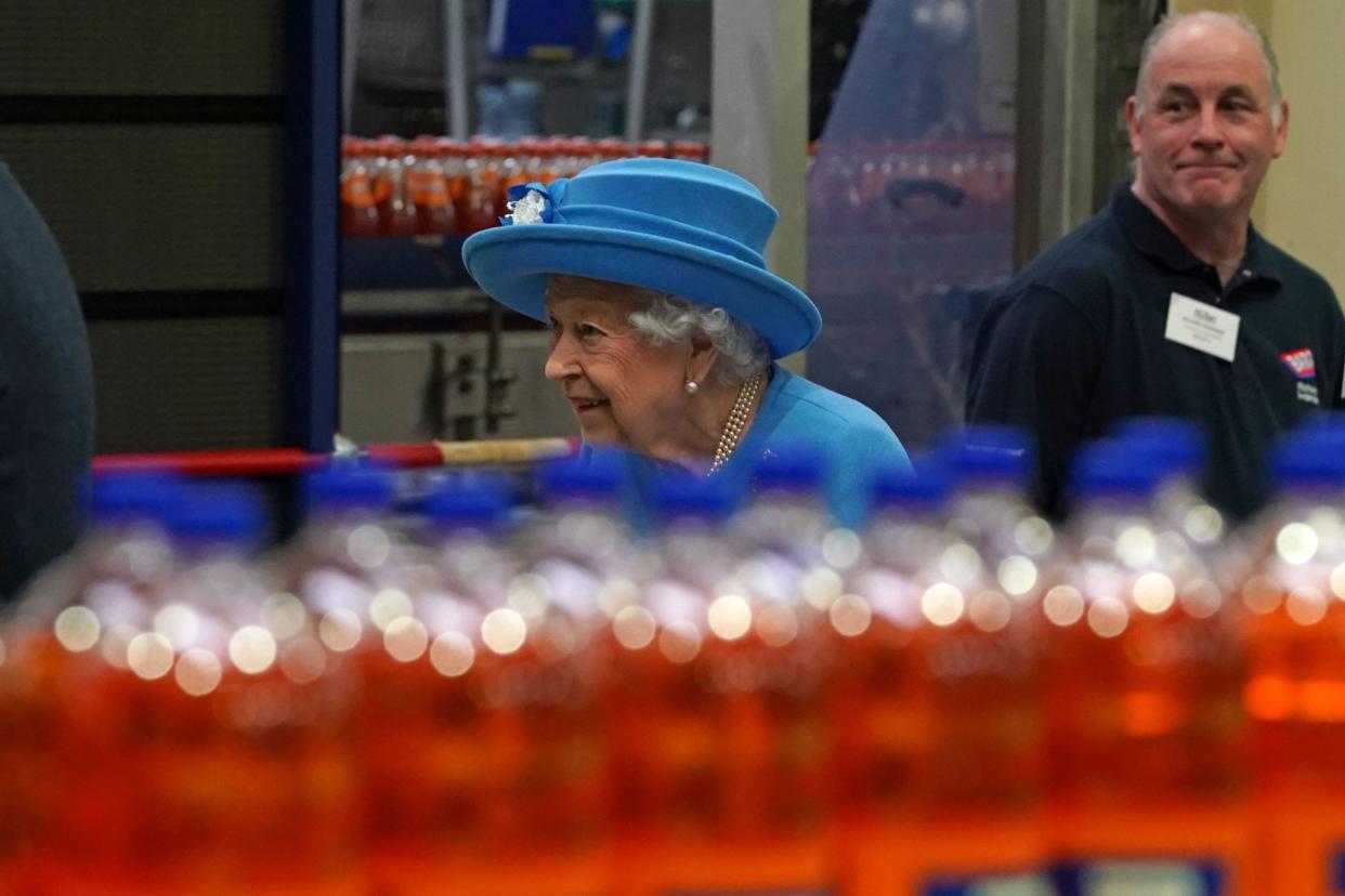 Britain's Queen Elizabeth II tours the production line during a visit to AG Barr's factory in Cumbernauld, east of Glasgow, where the Irn-Bru drink is manufactured on June 28, 2021. - The Queen is in Scotland for Royal Week where she will be undertaking a range of engagements celebrating community, innovation and history. (Photo by Andrew Milligan / POOL / AFP) (Photo by ANDREW MILLIGAN/POOL/AFP via Getty Images)