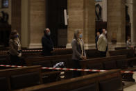 Faithful wearing gloves and face masks to prevent the spread of COVID-19, pray during the morning mass at St. Eugenio Church, in Rome, Monday, May 18, 2020. Italy partially lifted sanitary restrictions Monday after a two-month coronavirus lockdown. (AP Photo/Alessandra Tarantino)