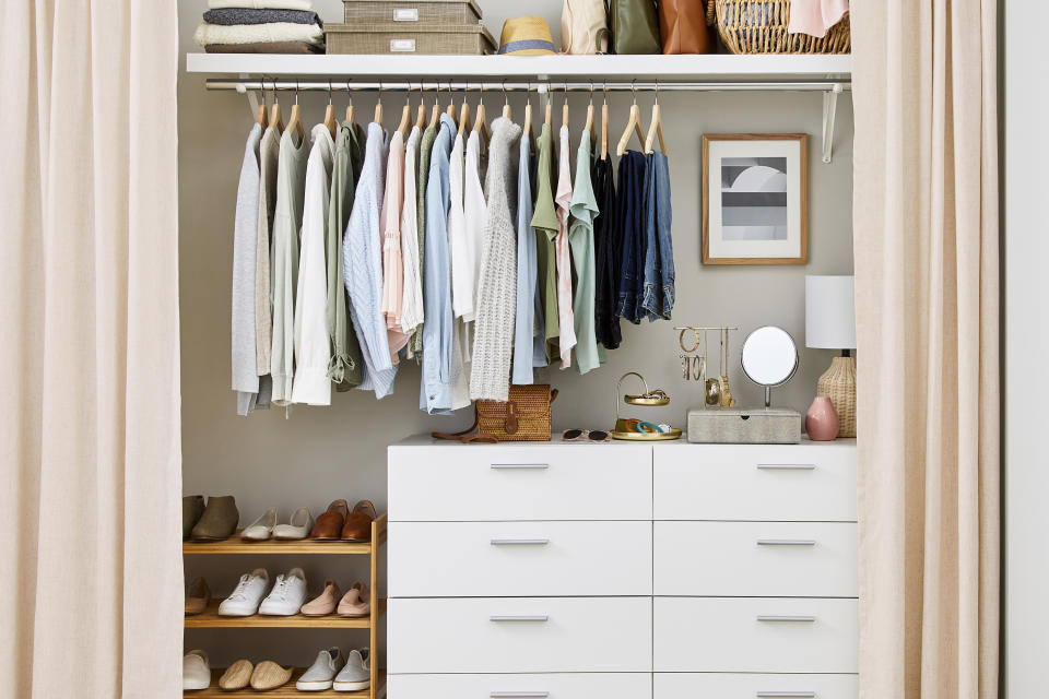 This photo provided by The Spruce shows a closet with a curtain instead of the original old doors. Experts say removing old doors and replacing them with a tension rod and chic curtains is a quick and inexpensive way to refresh a room, especially if the doors are in bad shape. (Marty Baldwin/The Spruce via AP)