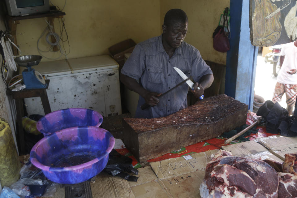 A man sells meat on a street in Conakry, Guinea, Thursday, Sept. 9, 2021. Guinea's new military leaders sought to tighten their grip on power after overthrowing President Alpha Conde, warning local officials that refusing to appear at a meeting convened Monday would be considered an act of rebellion against the junta. (AP Photo/Sunday Alamba)