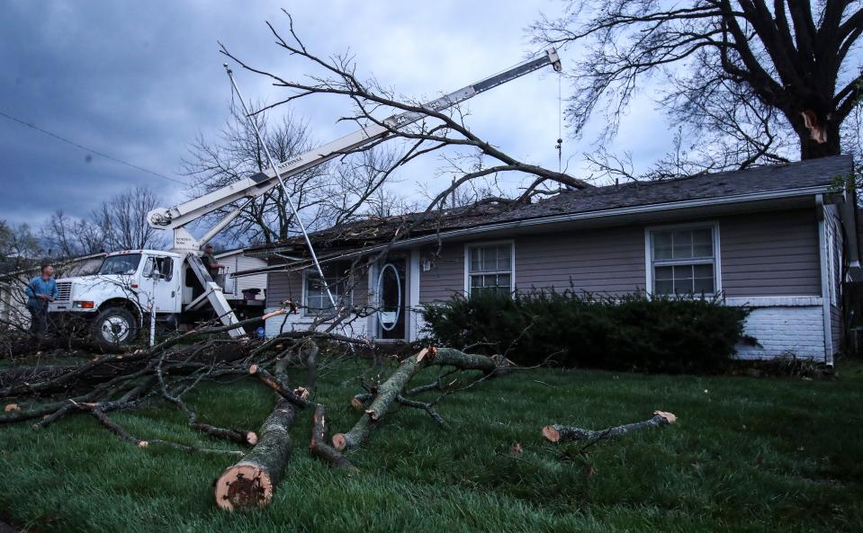 A crane with SYS Enterprises lifts a limb off a house in New Albany which was damaged after strong winds hit the Southern Indiana area Tuesday. April 2, 2024