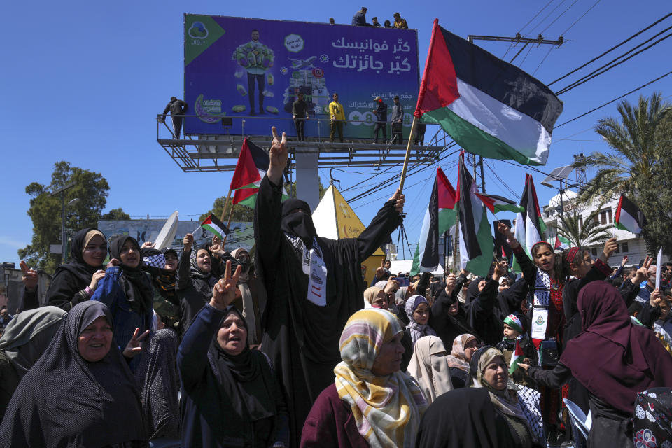 Women wave Palestinian flags and chant slogans during a rally in solidarity with Palestinian residents of the West Bank and Jerusalem, in Gaza City, Friday, April 15, 2022. Tensions have soared in recent weeks following a series of attacks by Palestinians that killed 14 people inside Israel. Israel has carried out a wave of arrests and military operations across the occupied West Bank, setting off clashes with Palestinians. At least 25 Palestinians have been killed in the recent wave of violence, many of whom had carried out attacks or were involved in the clashes, but also an unarmed woman and a lawyer who appears to have been killed by mistake. (AP Photo/Adel Hana)