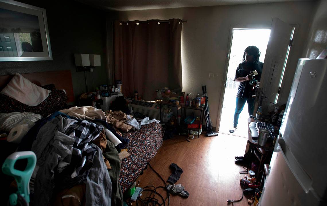 Housekeeper Janelle Wright peeks into a room where a person had been living without paying at the HomeTowne Studios hotel on Hosmer Street in Tacoma, Washington on July 8, 2022. Wright said the staff is unable to deal with illegal activity, and police will not respond for non-violent crimes.