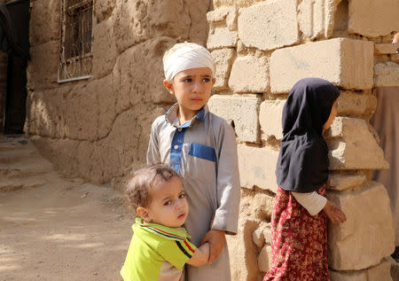 Mukhtar Hadi, who survived survived last month's Saudi-led air strike that killed dozens including children, stands with his brother and sister in Saada, Yemen September 4, 2018. Picture taken September 4, 2018. REUTERS/Naif Rahma