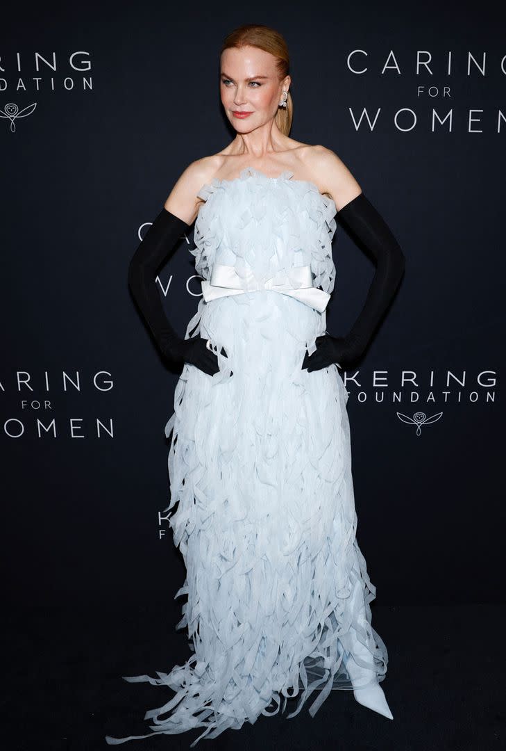 Nicole Kidman optó por un dramático vestido strapless de Balenciaga, en blanco y con tiras de tul que simulaban plumas y le aportaban volumen al volumen. Coronó el look con largos guantes negros.