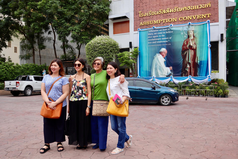 In this Sept. 8, 2019, photo, Catholic churchgoers pose in front of Pope Francis image outside a church in Bangkok, Thailand. The Vatican said Friday, Sept. 13, 2019, Pope Francis will visit Thailand and Japan on Nov. 19-26. (AP Photo/Kiko Rosario)