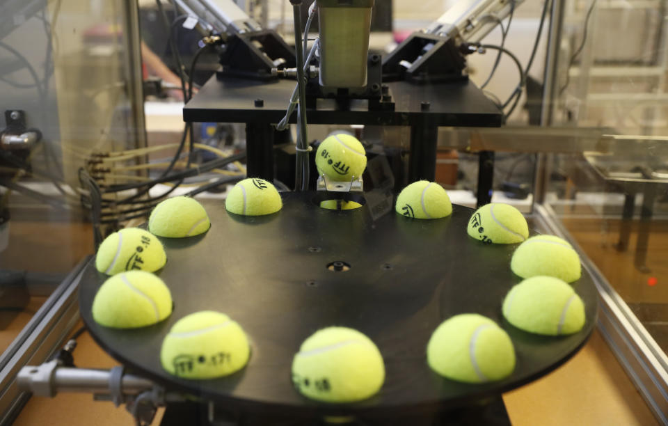 In this photo taken Friday June, 28, 2019, a tennis balls are lined up to squashed by pistons as they are tested by the International Tennis Federation (ITF) lab in Roehampton, near Wimbledon south west London. Based for about 20 years in a three-room area on what used to be a pair of squash courts in Roehampton, the ITF tech lab is filled with more than $1 million worth of machines that help make sure rules are followed and parameters are met. (AP Photo/Alastair Grant)