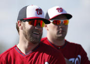 Washington Nationals left fielder Bryce Harper, left, smiles with Ryan Zimmerman during a spring training baseball workout, Thursday, Feb. 20, 2014, in VIera, Fla. (AP Photo/Alex Brandon)