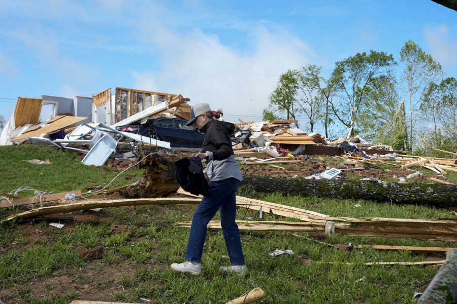 Valerie Bernhart searches for belongings outside her storm damaged home Thursday, May 9, 2024, in Spring Hill, Tenn. Severe storms tore through the central and southeast U.S., Wednesday, spawning damaging tornadoes, producing massive hail, and killing several people in Tennessee. (AP Photo/George Walker IV)