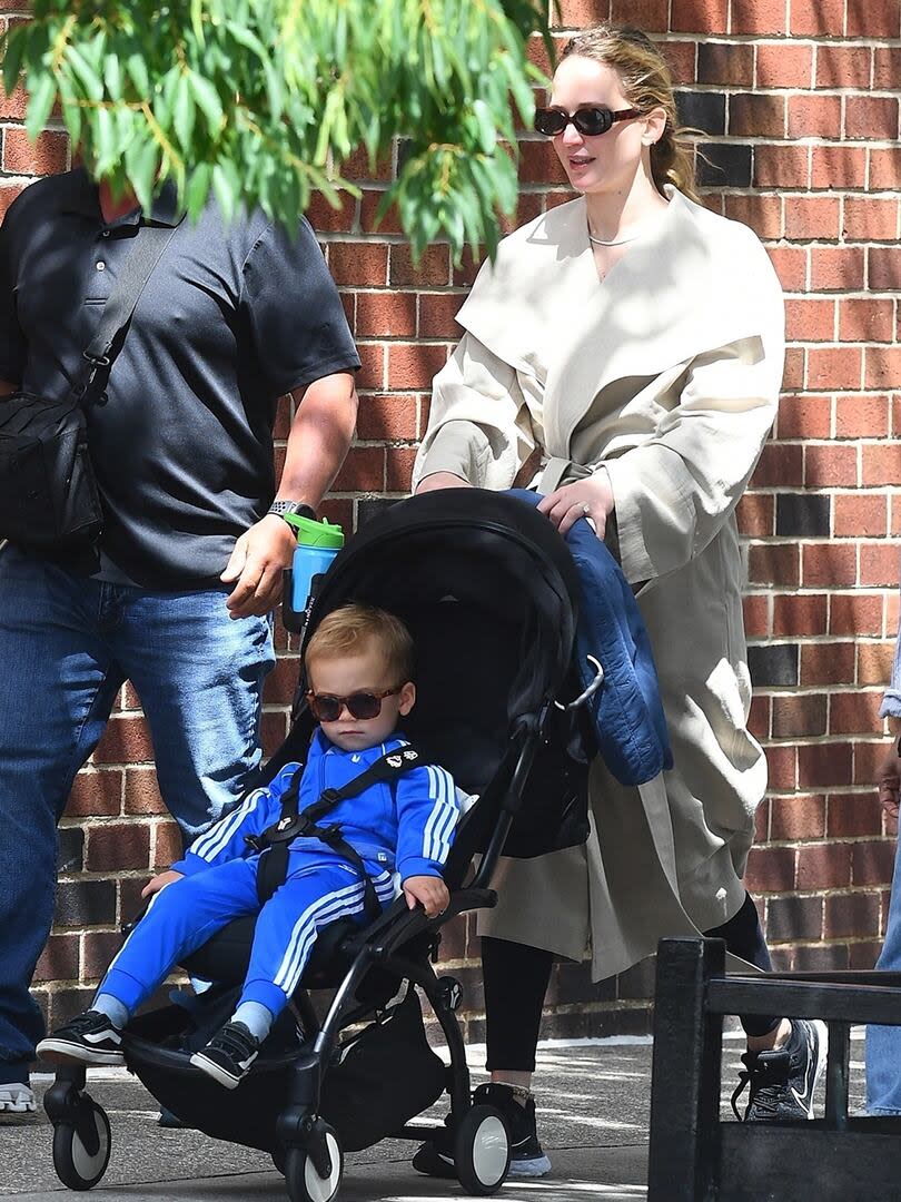 Wearing a brown trench coat over black leggings and sunglasses, Jennifer Lawrence hit the gym after playing in the park with her son Sy Maroney at a park in New York.  The boy seems to have inherited his mother's style and caught the eye when he was photographed wearing dark glasses and a vibrant blue tracksuit.