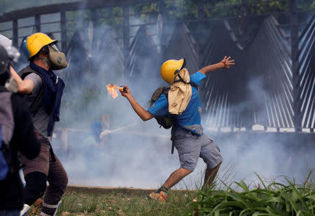 Demonstrators clash with riot security forces at the fence of an air base while rallying against Venezuela's President Nicolas Maduro in Caracas, Venezuela. REUTERS/Carlos Garcia Rawlins