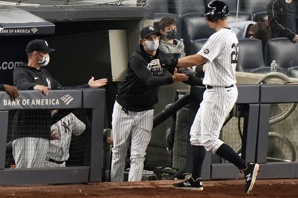 New York Yankees manager Aaron Boone greets DJ LeMahieu (26) at the dugout steps as LeMahieu scored on a bases-loaded walk during the eighth inning of an interleague baseball game against the Atlanta Braves, Tuesday, April 20, 2021, at Yankee Stadium in New York. (AP Photo/Kathy Willens)