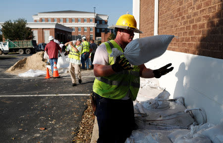 Workers of Sumter Utilities place sand bags on a building in anticipation of flood waters in the aftermath of Hurricane Florence now downgraded to a tropical depression in Conway, South Carolina, U.S., September 20, 2018. REUTERS/Randall Hill