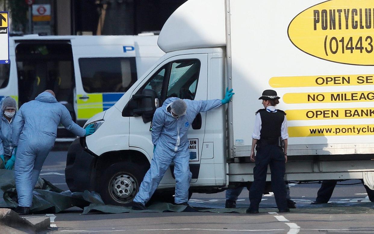 Forensic officers examine the van used to mow down Muslim worshipers in Finsbury Park, north London, on June 19, 2017. - AP