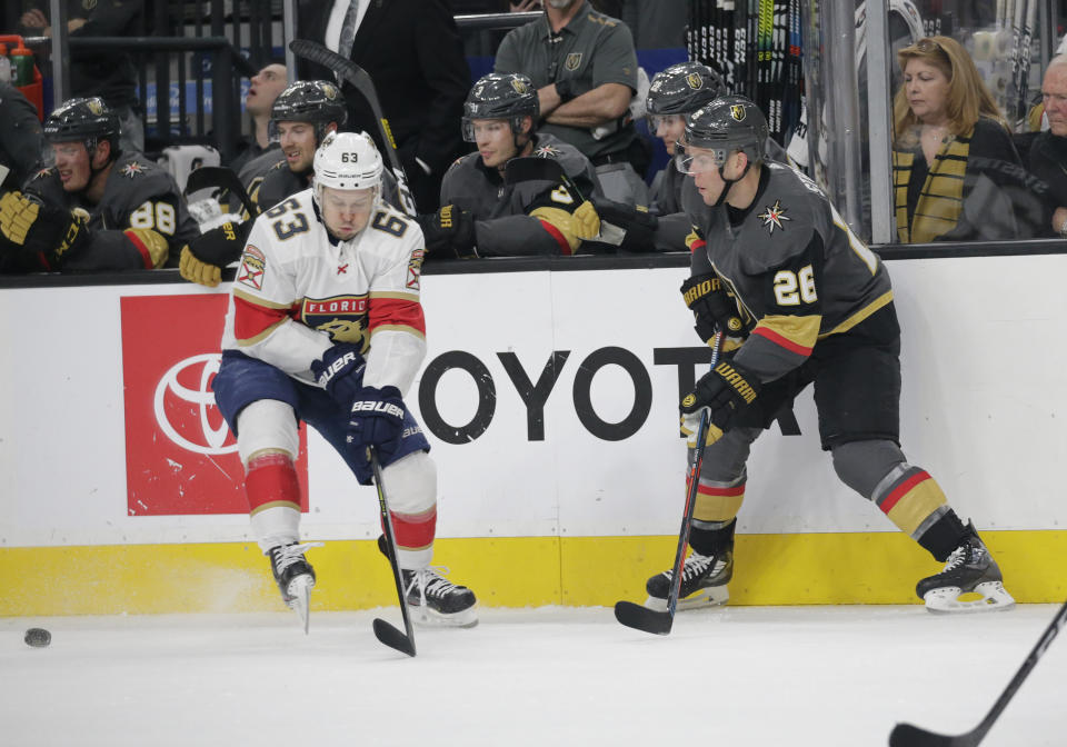 Vegas Golden Knights center Paul Stastny (26) passes the puck past Florida Panthers right wing Evgenii Dadonov (63) during the first period of an NHL hockey game Saturday, Feb. 22, 2020, in Las Vegas. (AP Photo/Marc Sanchez)