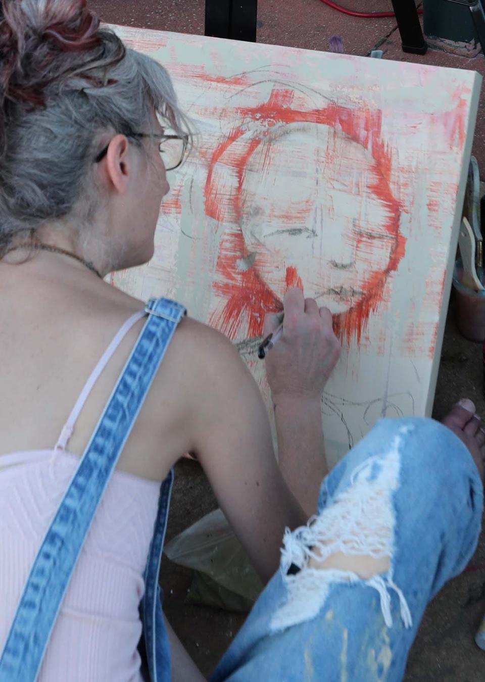 Nikki Bartel of Barberton paints during the Rally for Reproductive Justice at the Cuyahoga Falls Pavilion and Amphitheater on Tuesday.