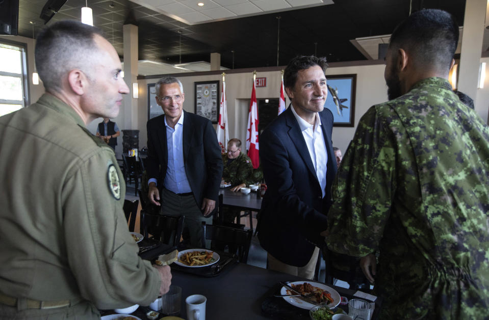 Canadian Prime Minister Justin Trudeau, right, and NATO Secretary General Jens Stoltenberg, back left, meet with the military during a luncheon with members of the Canadian Armed Forces at 4 Wing Cold Lake air base in Cold Lake, Alberta, on Friday, Aug. 26, 2022. (Jason Franson/The Canadian Press via AP)