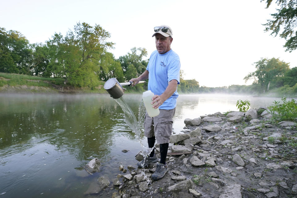 Des Moines Water Works employee Bill Blubaugh collects a water sample from the Raccoon River, Thursday, June 3, 2021, in Des Moines, Iowa. Each day the utility analyzes samples from the Raccoon River and others from the nearby Des Moines River as it works to deliver drinking water to more than 500,000 people in Iowa's capital city and its suburbs. (AP Photo/Charlie Neibergall)