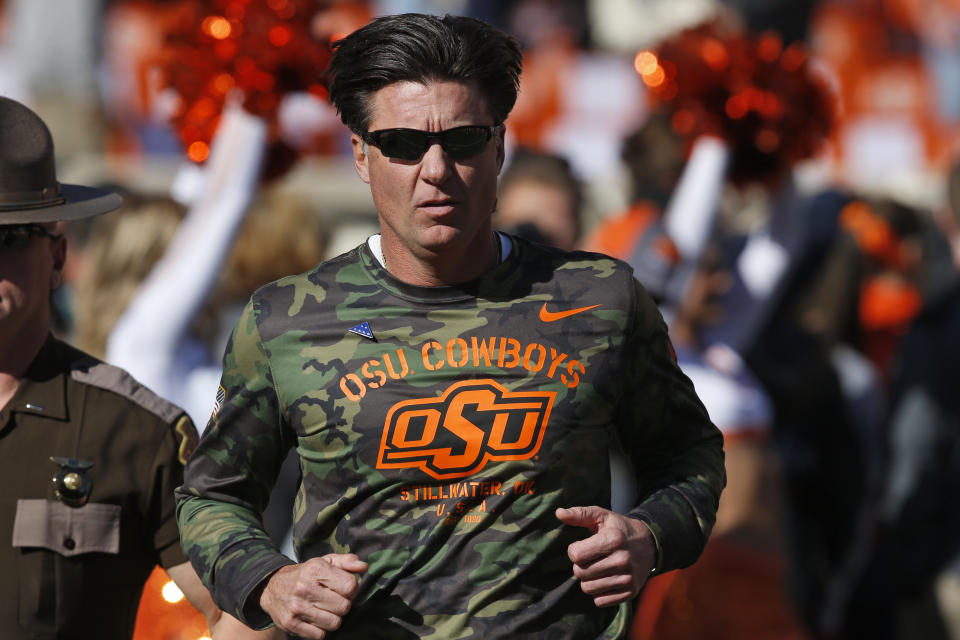 Oklahoma State head coach Mike Gundy runs onto the field before an NCAA college football game against Kansas in Stillwater, Okla., Saturday, Nov. 16, 2019. (AP Photo/Sue Ogrocki)