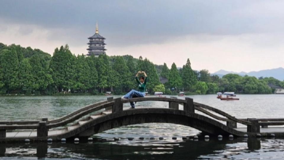 蔡依林遊覽西湖美景，開心坐在橋邊比愛心。（圖／翻攝自蔡依林IG）