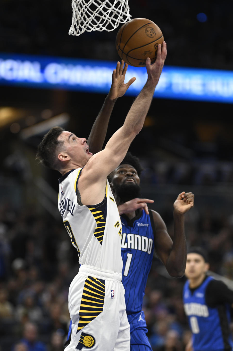 Indiana Pacers guard T.J. McConnell (9) goes up to shoot as Orlando Magic forward Jonathan Isaac (1) defends during the second half of an NBA basketball game, Sunday, March 10, 2024, in Orlando, Fla. (AP Photo/Phelan M. Ebenhack)