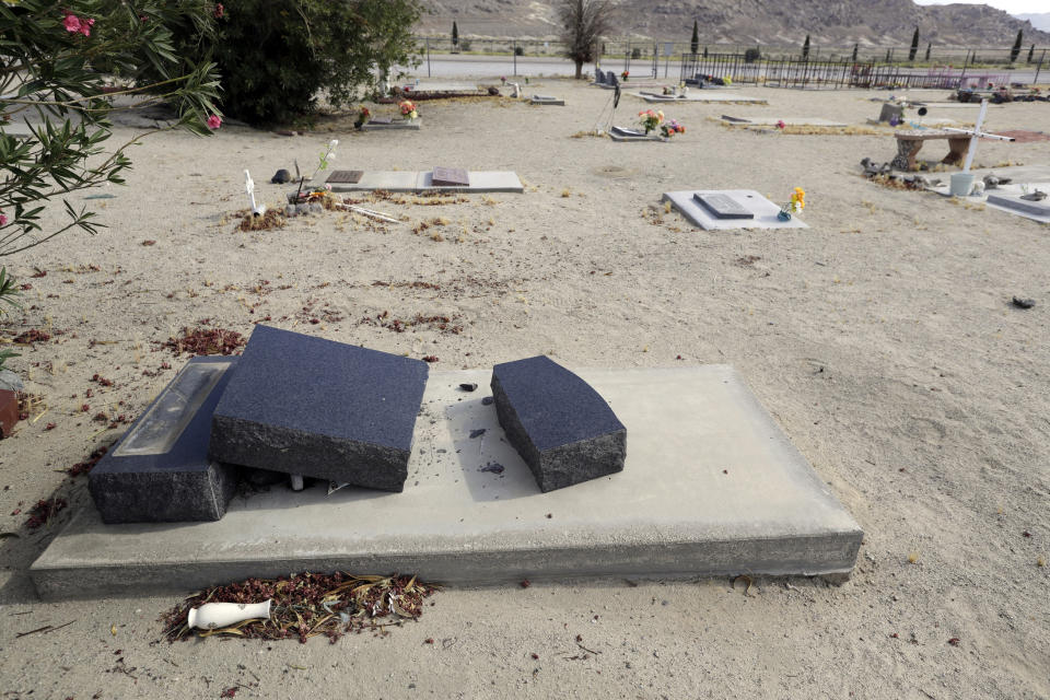 A gravestone is tumbled over onto a grave in the aftermath of an earthquake at the Searles Valley Cemetery Sunday, July 7, 2019, in Trona, Calif. (AP Photo/Marcio Jose Sanchez)