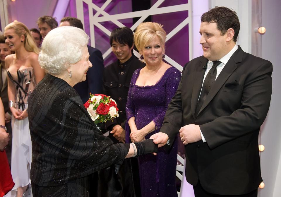 Schauspielerin Bette Midler (Mitte, hier mit Comedian Peter Kay) stand der Queen (links) bereits persönlich gegenüber. Sie beschreibt die Monarchin bei Twitter als "unerschütterlich, standhaft und bis zum Schluss engagiert". Außerdem hob Midler die lange Amtszeit hervor: "70 Dienstjahre. Unglaublich." (Bild: 2009 Getty Images / WPA Pool)
