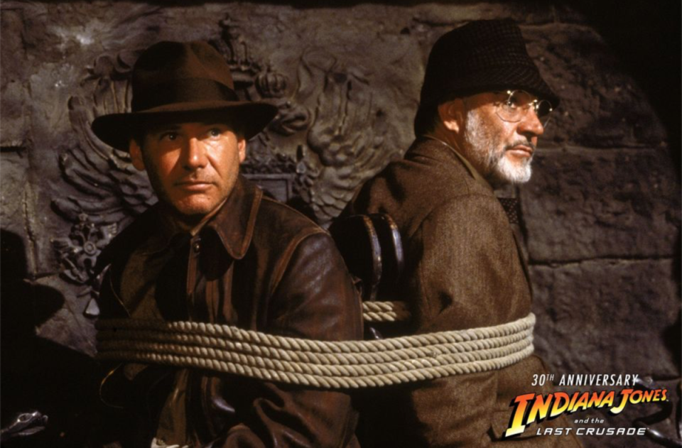 史恩康納萊（右）在《聖戰奇兵》與哈里遜福特（左）搭檔演父子，但其實在拍這一幕被困在大火之中，因為太熱，所以他率先決定不穿長褲。（翻攝自Indiana Jones官方Facebook）