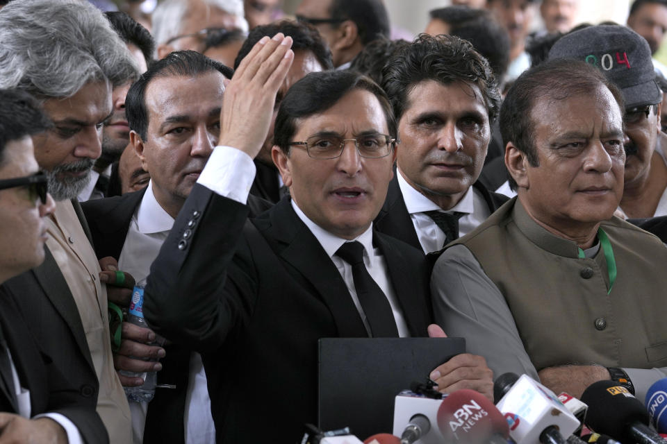 Chairman of Pakistan's Tehreek-e-Insaf party Gohar Khan, center, talks to the media while party supporters react after a Supreme Court decision in a case of reserved seats for women and minorities in parliament, in Islamabad, Pakistan, Friday, July 12, 2024. Pakistan's top court on Friday ruled that the party of imprisoned former Prime Minister Khan is eligible for seats reserved in the parliament, a major blow to the country's weak coalition government. (AP Photo/Anjum Naveed)