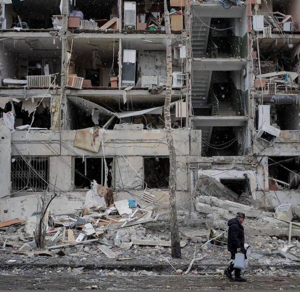 A resident walks passed a damaged building in Kharkiv  (Aleksandr Osadchy)