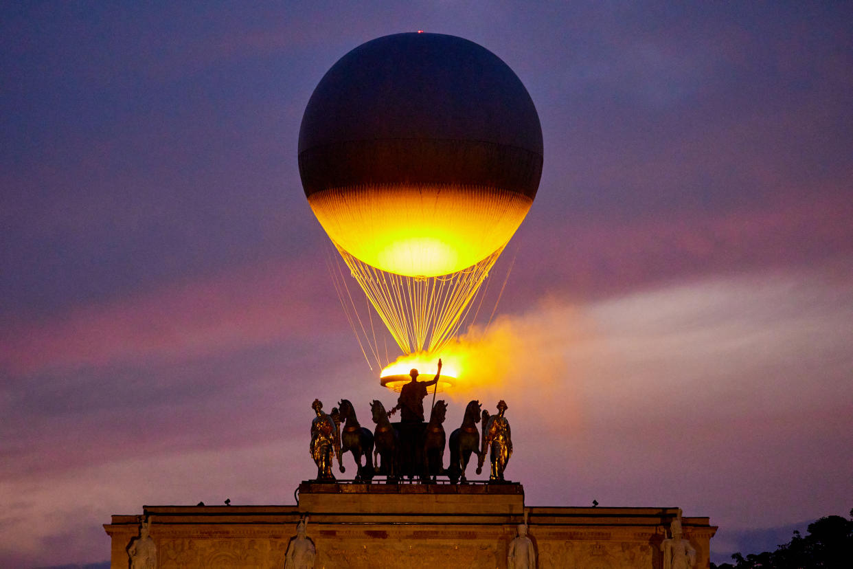 The cauldron with the Olympic flame seen from The Louvre in Paris