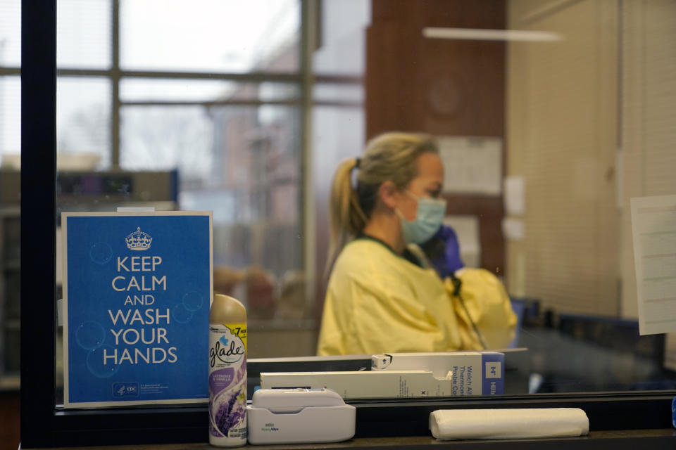 FILE - In this Nov. 24, 2020, file photo, registered nurse Chrissie Burkhiser works in the emergency room at Scotland County Hospital in Memphis, Mo. Arguments over mask requirements and other restrictions have turned ugly in recent days as the deadly coronavirus surge engulfs small and medium-size cities that once seemed a safe remove from the outbreak. (AP Photo/Jeff Roberson, File)