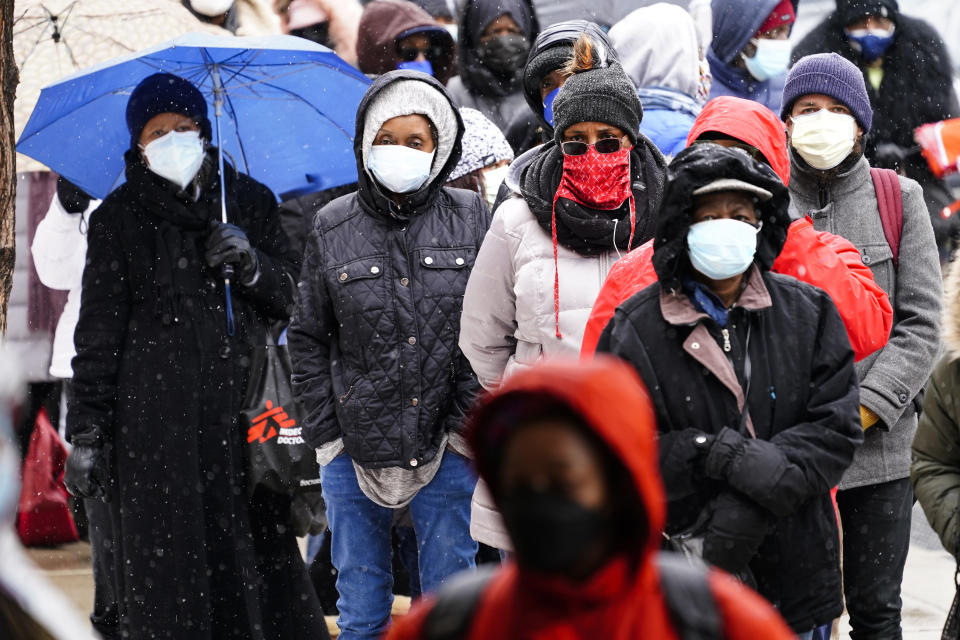 FILE - In this Feb. 19, 2021, file photo, people wait in line at a 24-hour, walk-up COVID-19 vaccination clinic hosted by the Black Doctors COVID-19 Consortium at Temple University's Liacouras Center in Philadelphia. At least for now, U.S. health authorities say after being vaccinated, people should follow the same rules as everybody else about wearing a mask, keeping a 6-foot distance and avoiding crowds even after they’ve gotten their second vaccine dose. (AP Photo/Matt Rourke, File)