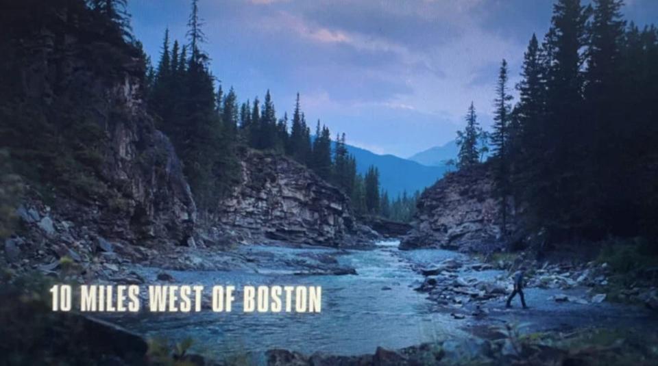 A creek with mountains in the background and a caption that says "10 miles west of Boston"