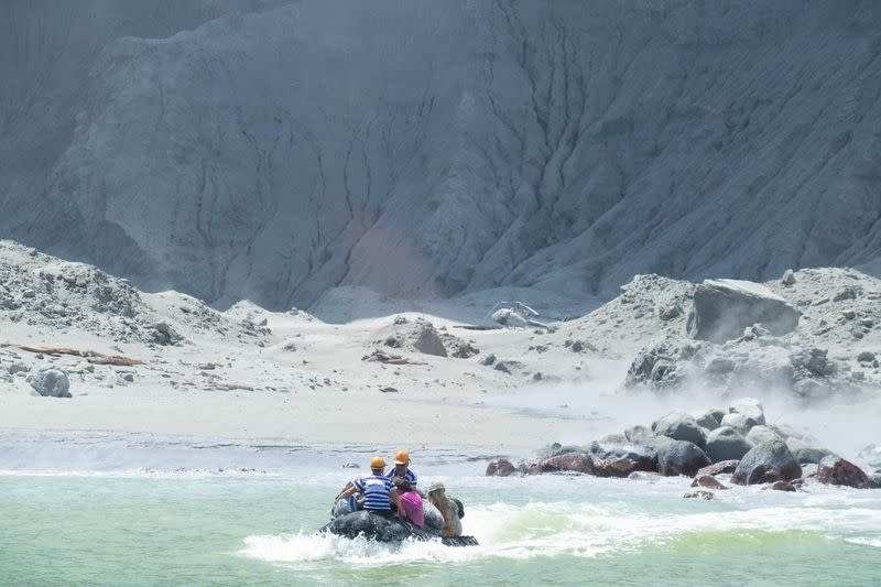 Tour guides evacuate tourists on a boat shortly after the volcano eruption on White Island