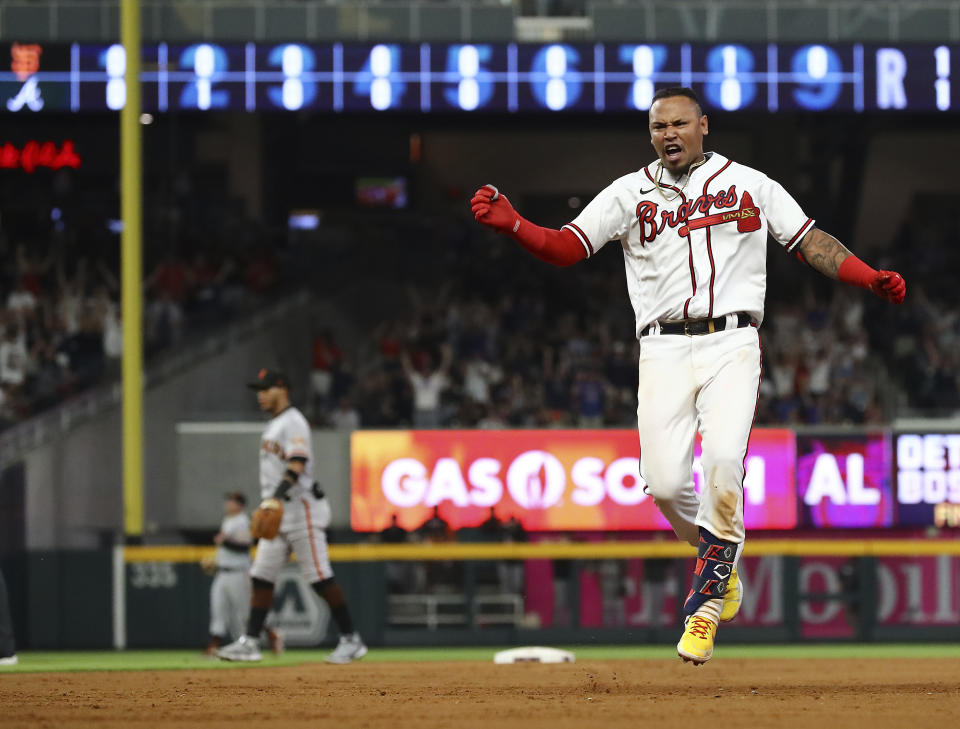 Giants players walk off the field as Atlanta Braves second baseman Orlando Arcia reacts to hitting a walk off single to beat the San Francisco Giants 2-1 during the ninth inning of a baseball game on Monday, June 20, 2022, in Atlanta. (Curtis Compton/Atlanta Journal-Constitution via AP)