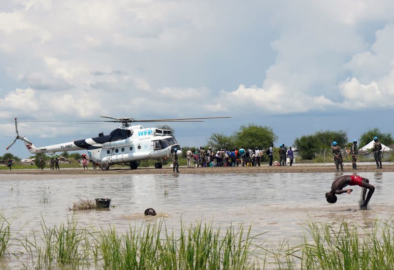 Children play in the floodwaters at the airstrip near a WFP helicopter, after the River Nile broke the dykes in Pibor