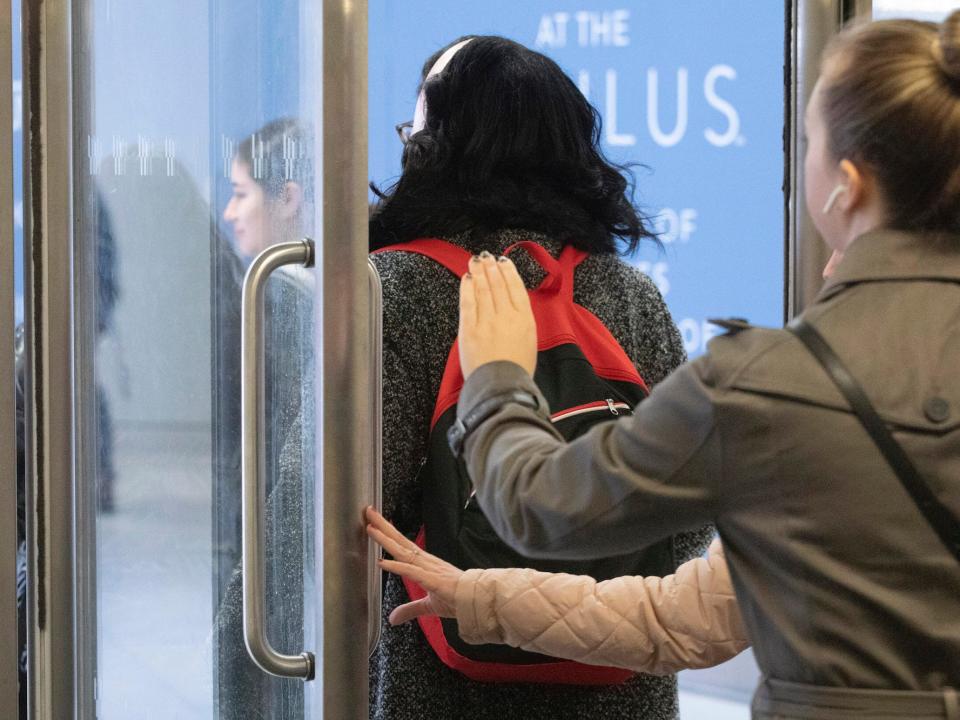 Women hold a door open as they exit a subway station, Wednesday, March 4, 2020, in New York.