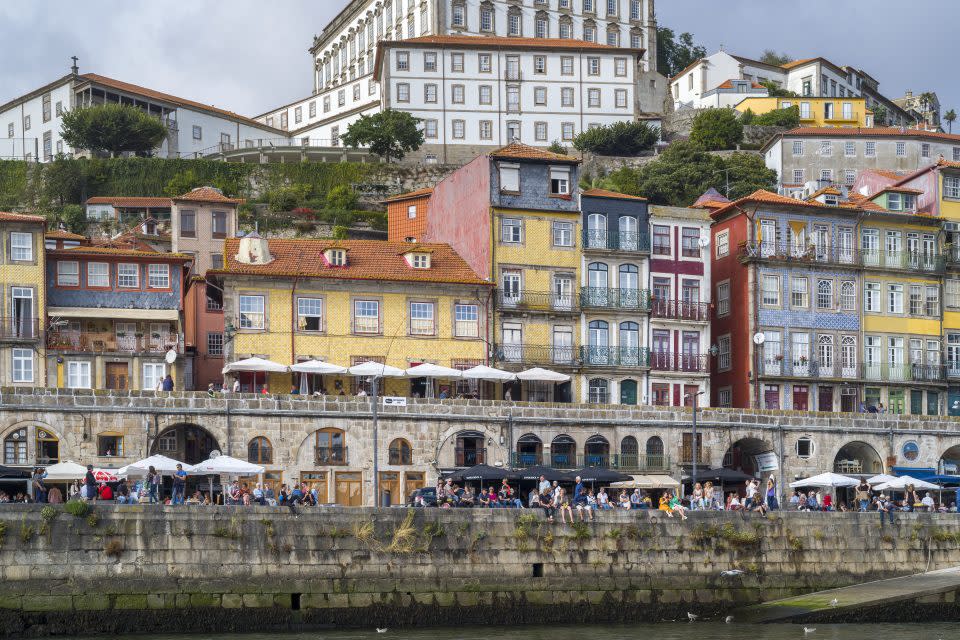 Riverside balconied homes and cafes in bright colours in Ribeira by the River Douro in Porto